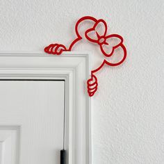 a white door with a red metal flower on it's side and a black pen in front of it