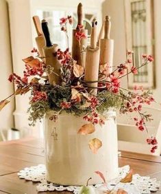 a vase filled with lots of different types of utensils on top of a wooden table