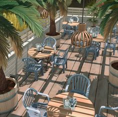 there are many wooden chairs and tables on the deck with palm trees in the background