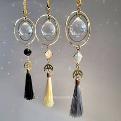 three different colored tassels hanging from gold chains with white and black beads on them