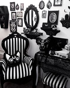 a black and white room with halloween decorations on the walls, striped chairs, and spider webs