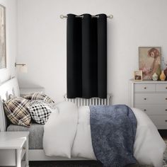 a bedroom with white walls and black curtains