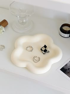 a white table topped with rings and other items