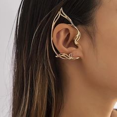 a woman wearing an ear cuff with leaves on it