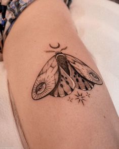 a small butterfly tattoo on the right side of the arm, with stars coming out of its wings