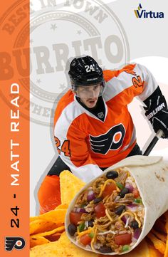 a man in an orange jersey is holding a burrito and some food on the table