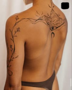 the back of a woman's body with tattoos on it