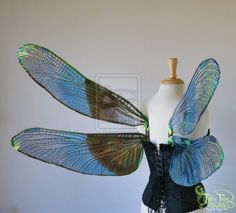 a mannequin with blue and green wings on it