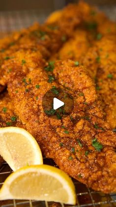 fried fish with lemons and parsley on the side, sitting on a cooling rack