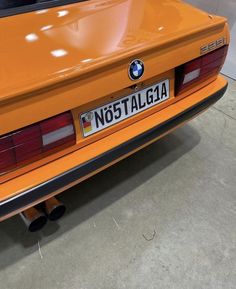 an orange bmw sports car parked in a garage with the license plate no5 talga