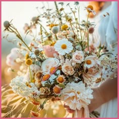 a woman holding a bouquet of flowers in her hands