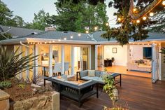 an outdoor living area with patio furniture and string lights