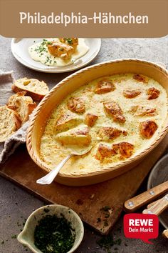 a casserole dish with bread and herbs on the side