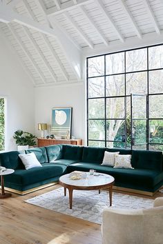 a living room filled with furniture and large windows