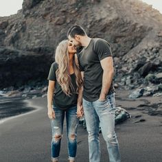 a man and woman kissing on the beach