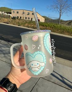 a person holding up a cup with a straw in it on the side of the road