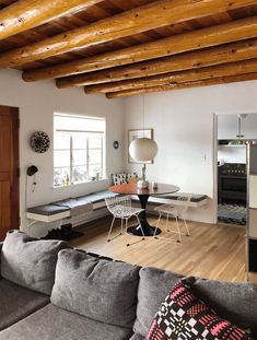 a living room filled with furniture and wooden beams