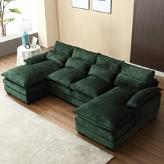 a large green couch sitting on top of a wooden floor next to a white rug