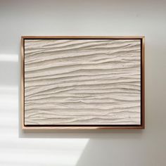 a white wall with a wooden frame hanging on it