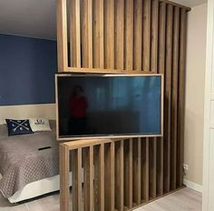 a bed room with a neatly made bed and a flat screen tv mounted on the wall