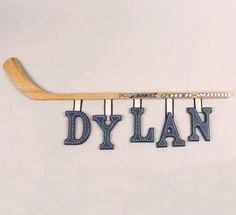 a hockey stick with the word dylan hanging from it's side on a wall