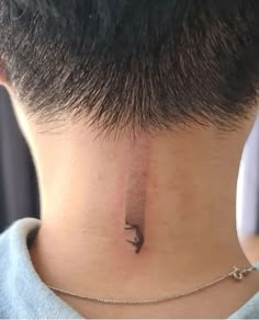 a person with a small tattoo on their neck