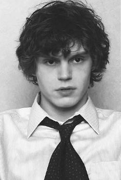 black and white photograph of a young man with curly hair wearing a shirt and tie