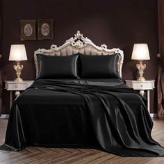 a bed covered in black sheets and pillows