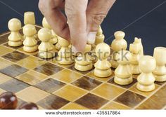 a man playing chess with his hand on the board