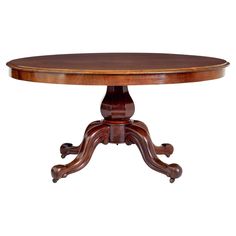 an oval wooden table with two leaves on the top and one leaf at the base