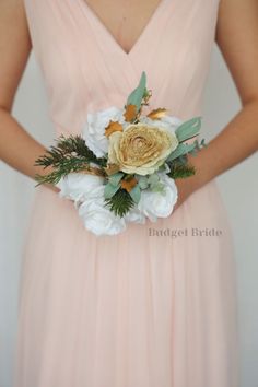 a bridesmaid in a pink dress holding a bouquet of white and gold flowers