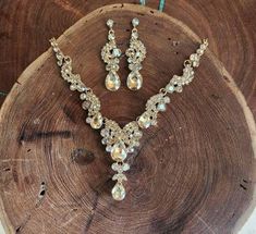 a necklace and earring set sitting on top of a piece of wood