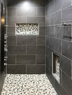 a walk in shower sitting next to a tiled wall