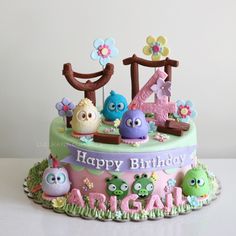 the birthday cake is decorated with fondant animals and numbers one to five on it