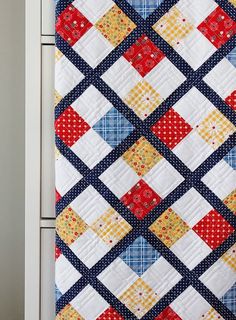 a close up of a quilt hanging on a cabinet door with the bottom half painted red, white and blue