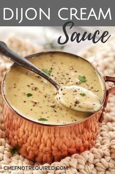 a close up of a bowl of soup with a spoon in it and the words dijon cream sauce on top