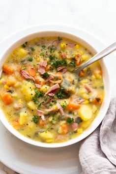 a white bowl filled with ham and potato soup