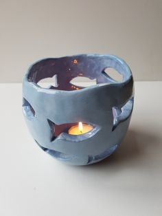 a blue bowl with two lit candles in it