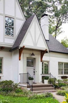 a white house with black trim on the front door and steps leading up to it