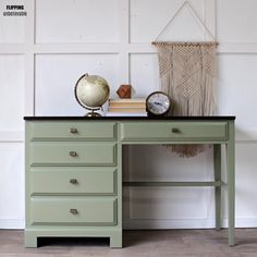 a green desk with two clocks on it