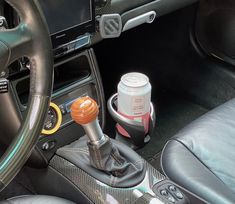 the interior of a car with a cup holder and steering wheel knobs on it