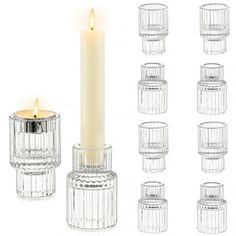 several clear glass candlesticks with a lit candle in the middle surrounded by smaller ones