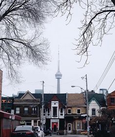 a street with cars parked on the side of it and a tall tower in the background