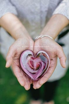 a person holding a heart shaped object in their hands