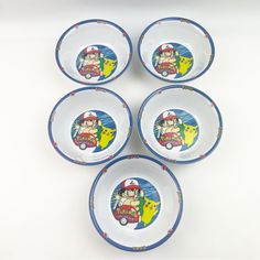 four plates with cartoon characters on them sitting next to each other in front of a white background