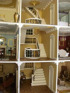 the inside of a doll house with stairs, furniture and chandeliers in it