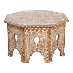 an ornately carved wooden table with intricate carvings on the top and bottom, against a white background