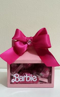 a candy box with a pink bow on the top and some candies in it