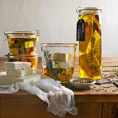 three jars filled with different types of food on top of a wooden table next to other containers