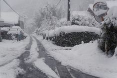 a snow covered street with cars parked on it